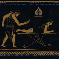 A man in gold standing over a woman laying dow on a table.
