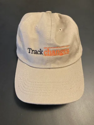 A baseball cap that has track changes written across the front. 